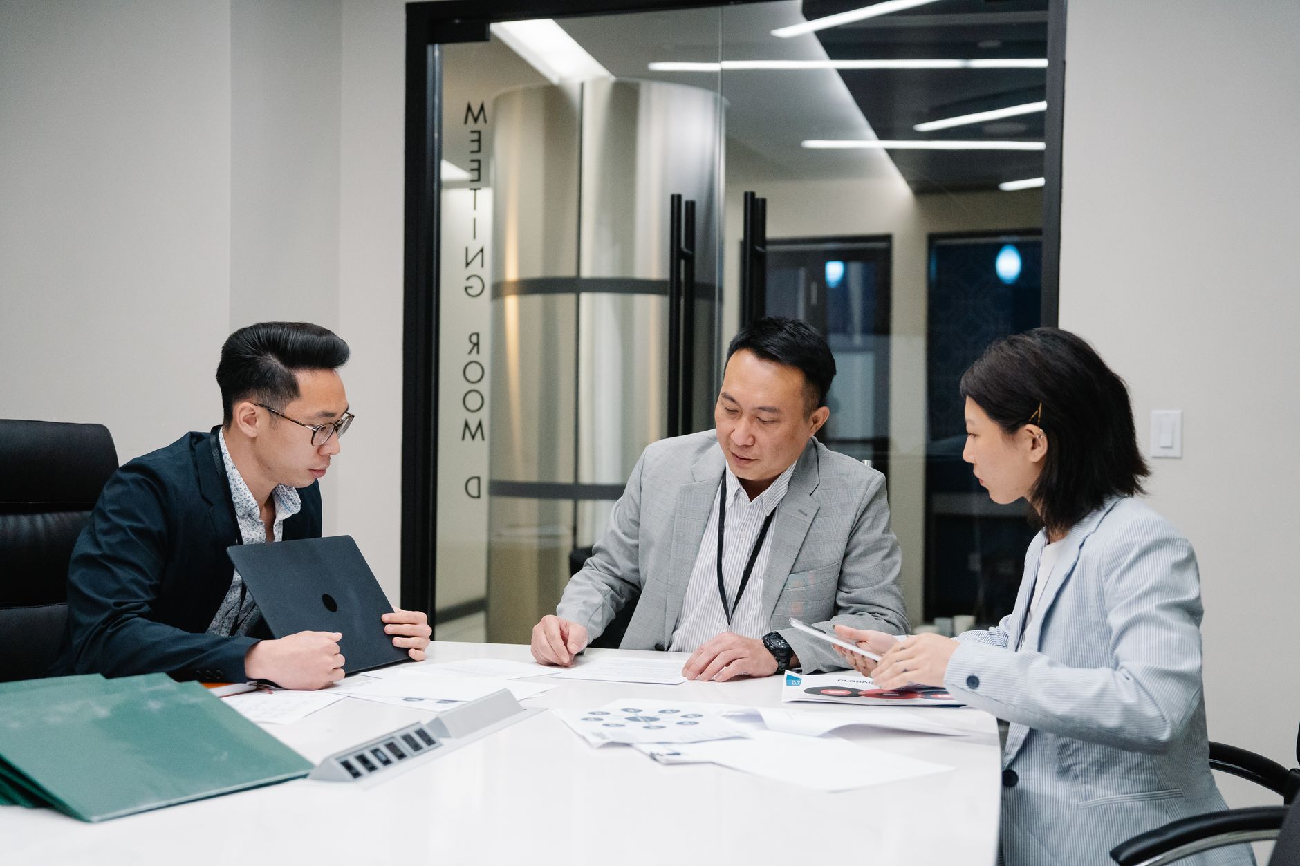 Three people reviewing papers at a table